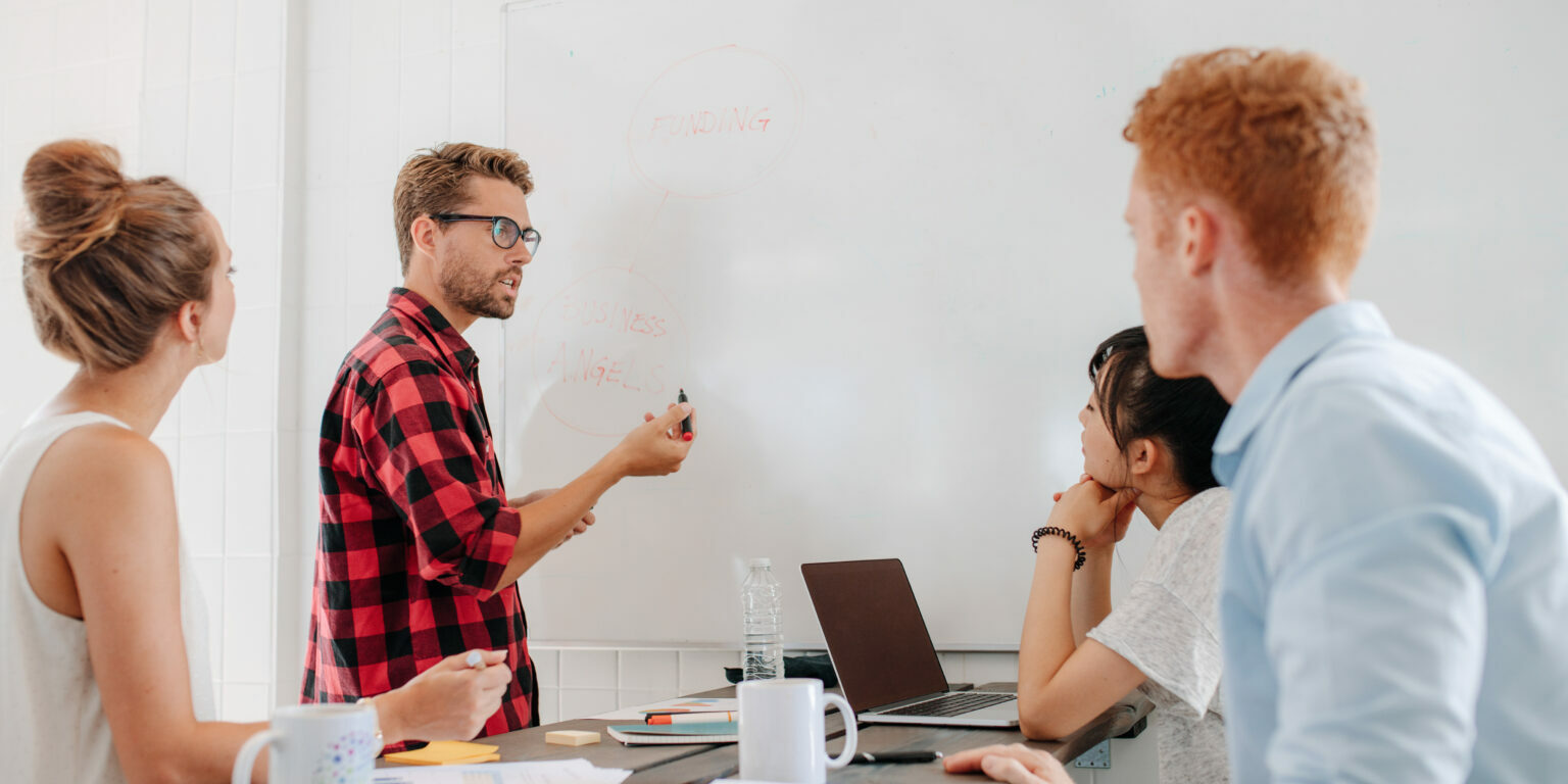 Executive explaining business plans to his coworkers executive explaining business plans to his coworkers